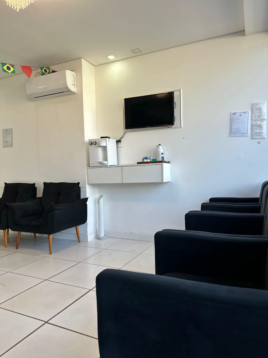 Sala de espera com poltronas, TV e água